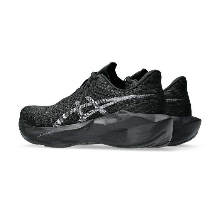 Снимка под ъгъл на маратонки Asics Novablast 6 в черно, видяни отстрани, показваща дебелата междинна подметка.